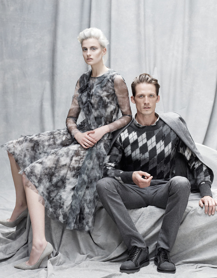 图中女士身着：葆蝶家（Bottega Veneta）薄纱裙（3,390英镑）。周仰杰（Jimmy Choo） 铆钉羊皮鞋（525英镑）。图中男士身着：葆蝶家（Bottega Veneta）法兰绒夹克（1,480英镑），搭配长裤（580英镑），羊毛罩衫（5,085英镑），纯棉衬衫（440英镑），达米尔·多马（Damir Doma）羊毛牛皮鞋（509英镑）。