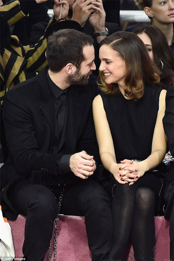 当地时间1月26日，娜塔丽·波特曼 (Natalie Portman) 身穿灰色七分袖大衣搭配同色丝质半身裙亮相2015春夏巴黎高定时装周迪奥 (Dior) 秀场前排，与老公Benjamin Millepied大秀恩爱羡煞旁人！